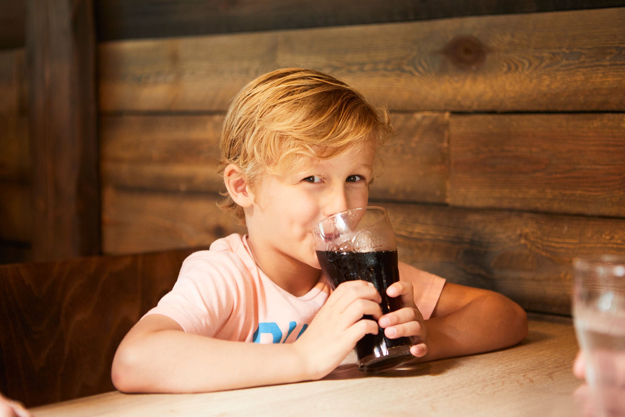 Jongen drinkt een cola in Aqua Bistro.
