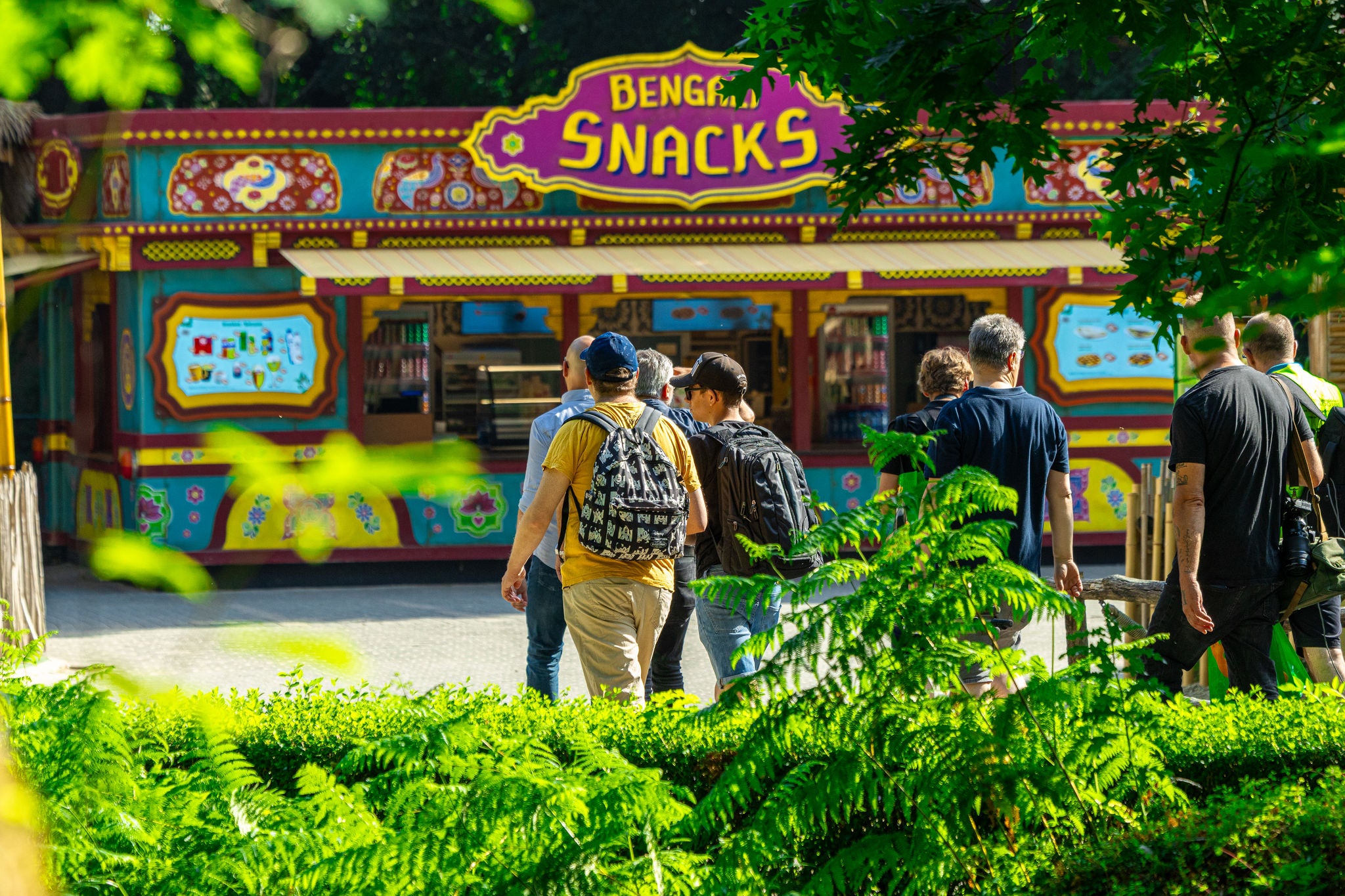 Bezoekers lopen door het groen richting Bengali Snacks.
