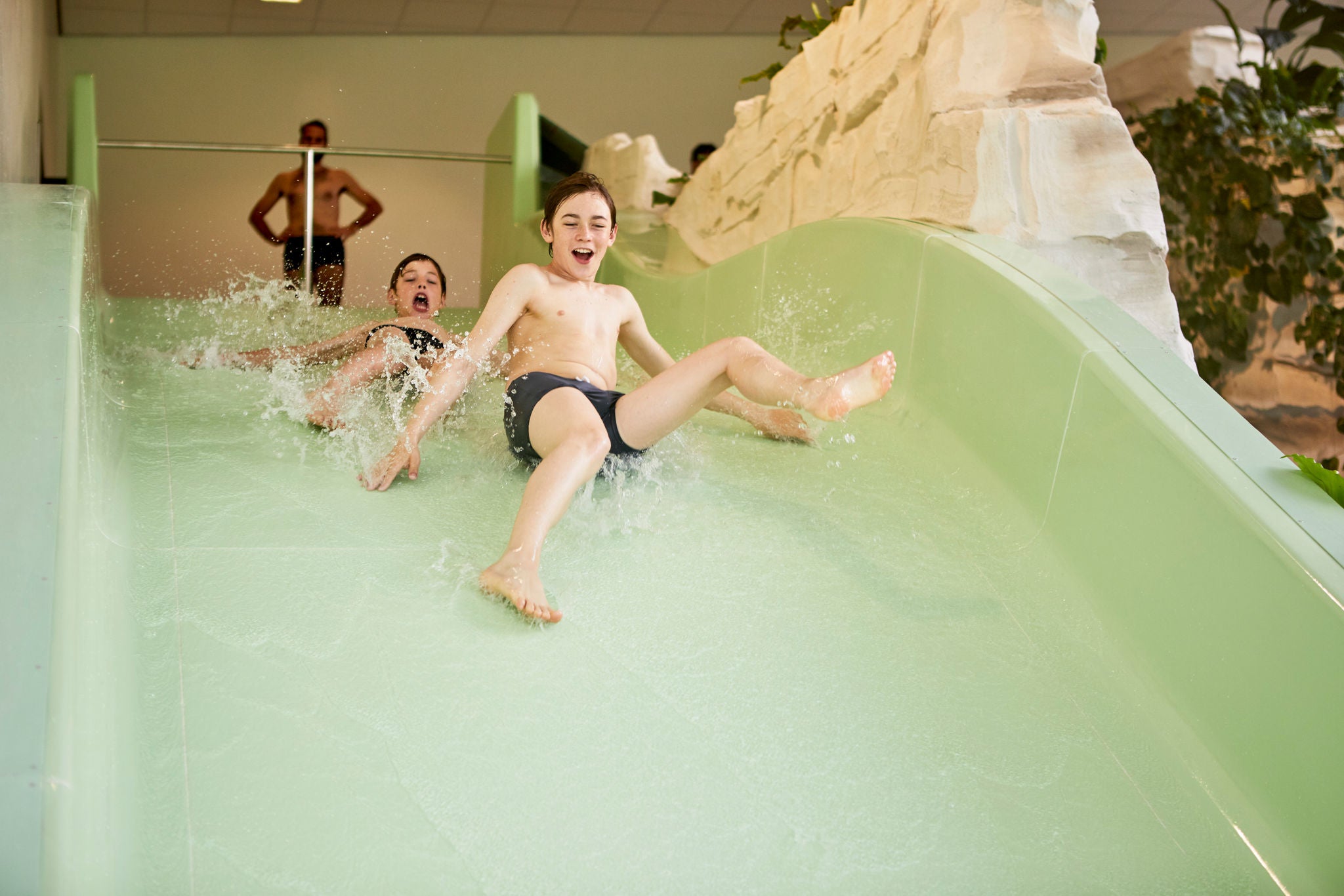 Jongens glijden samen van de Maxi Splash.