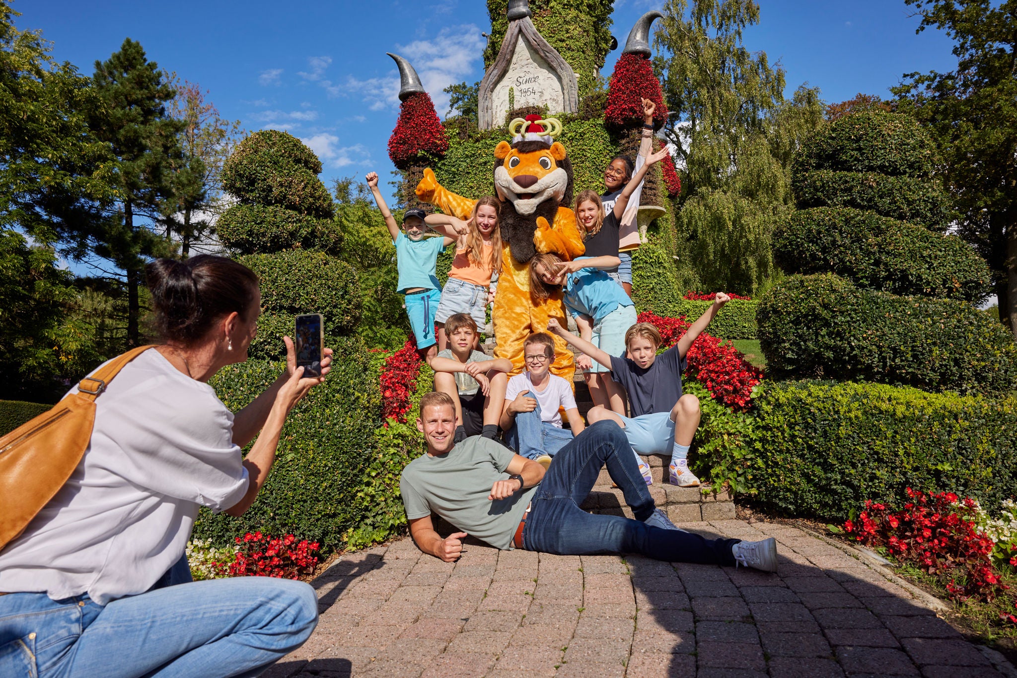 Fotomoment met Koning Leeuw, leerlingen en leerkracht bij het bloemenkasteel.