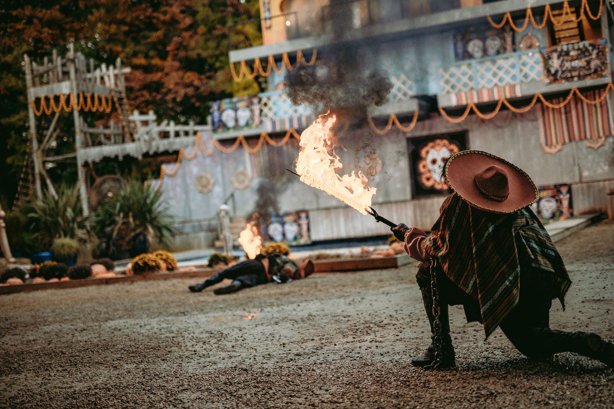 Bewoner knielt met een zwaard vol vuur tijdens El Portal De Los Muertos.