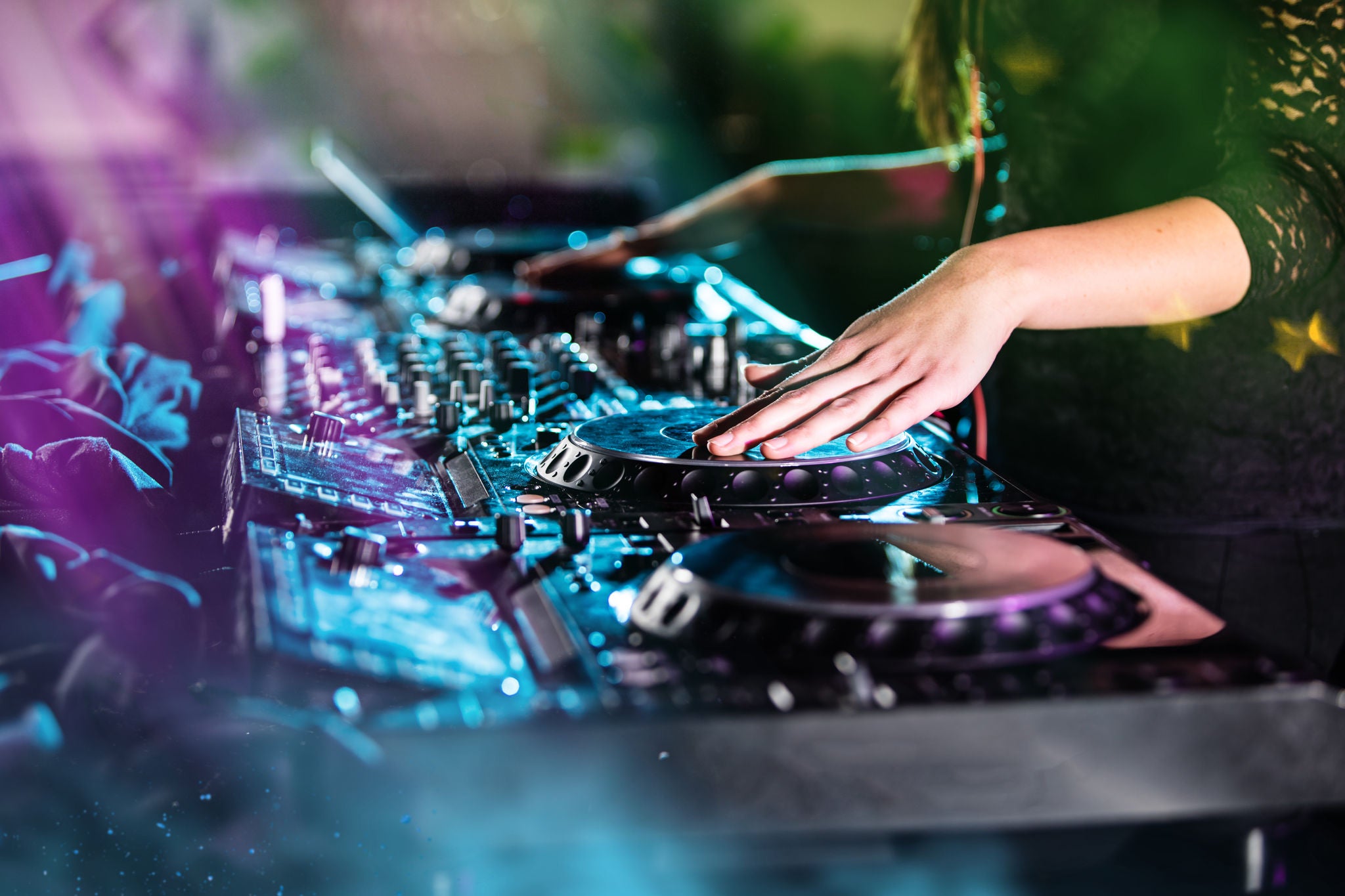 Dj mixes the track in the nightclub at a party, close-up.