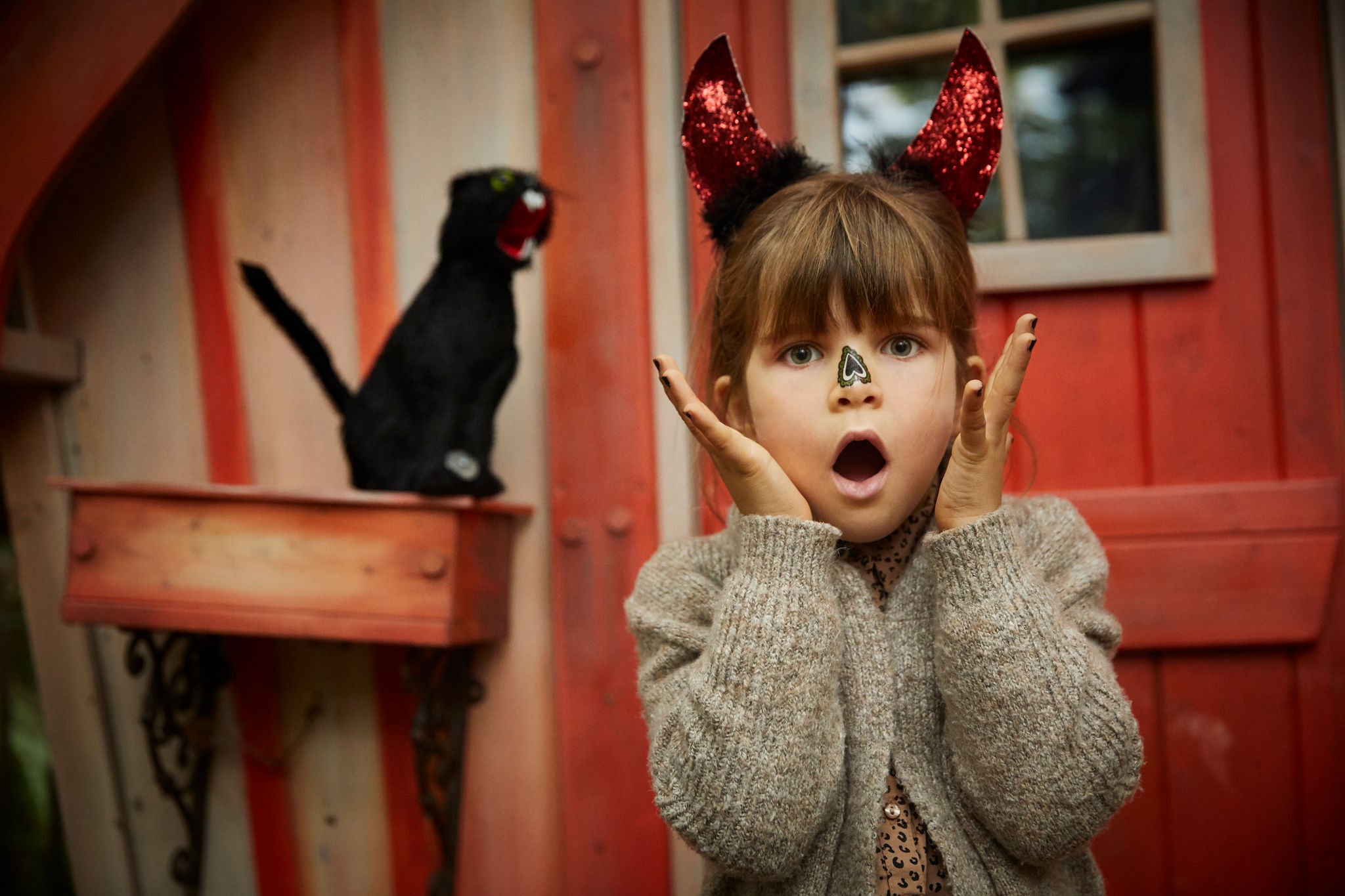 Meisje met een kat voor een huisje in Freaky Forest.