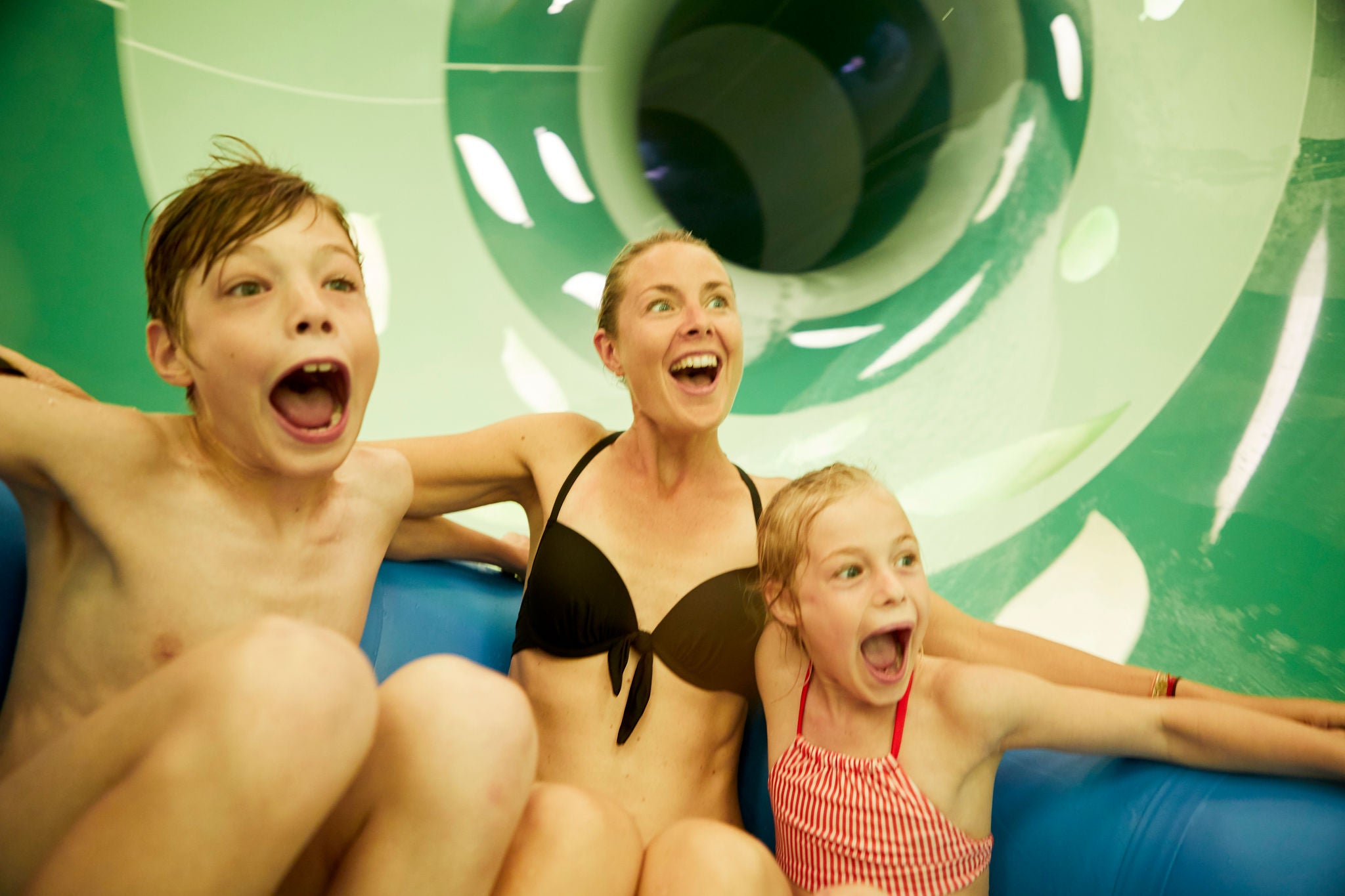 Mama glijdt samen met haar zoon en dochter in een band door de Aquaventure.