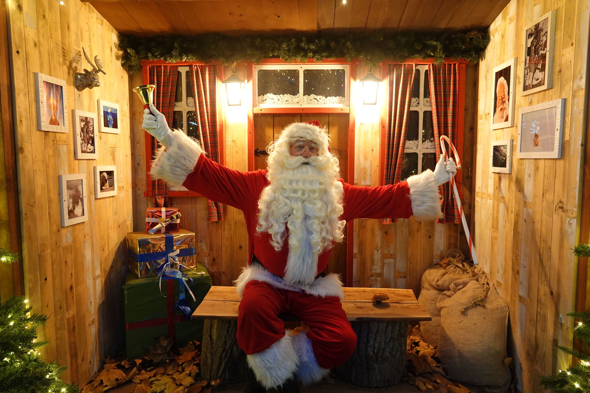 Kerstman met zijn bel en een zuurstok in een kerstchalet fotopunt.
