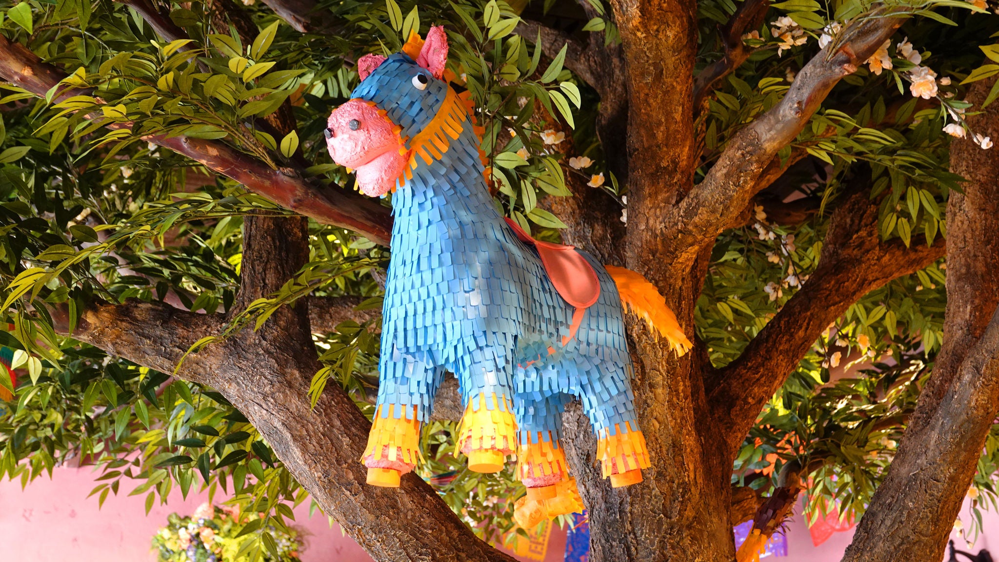Piñata in de vorm van een paard in een boom middenin La Piñata.
