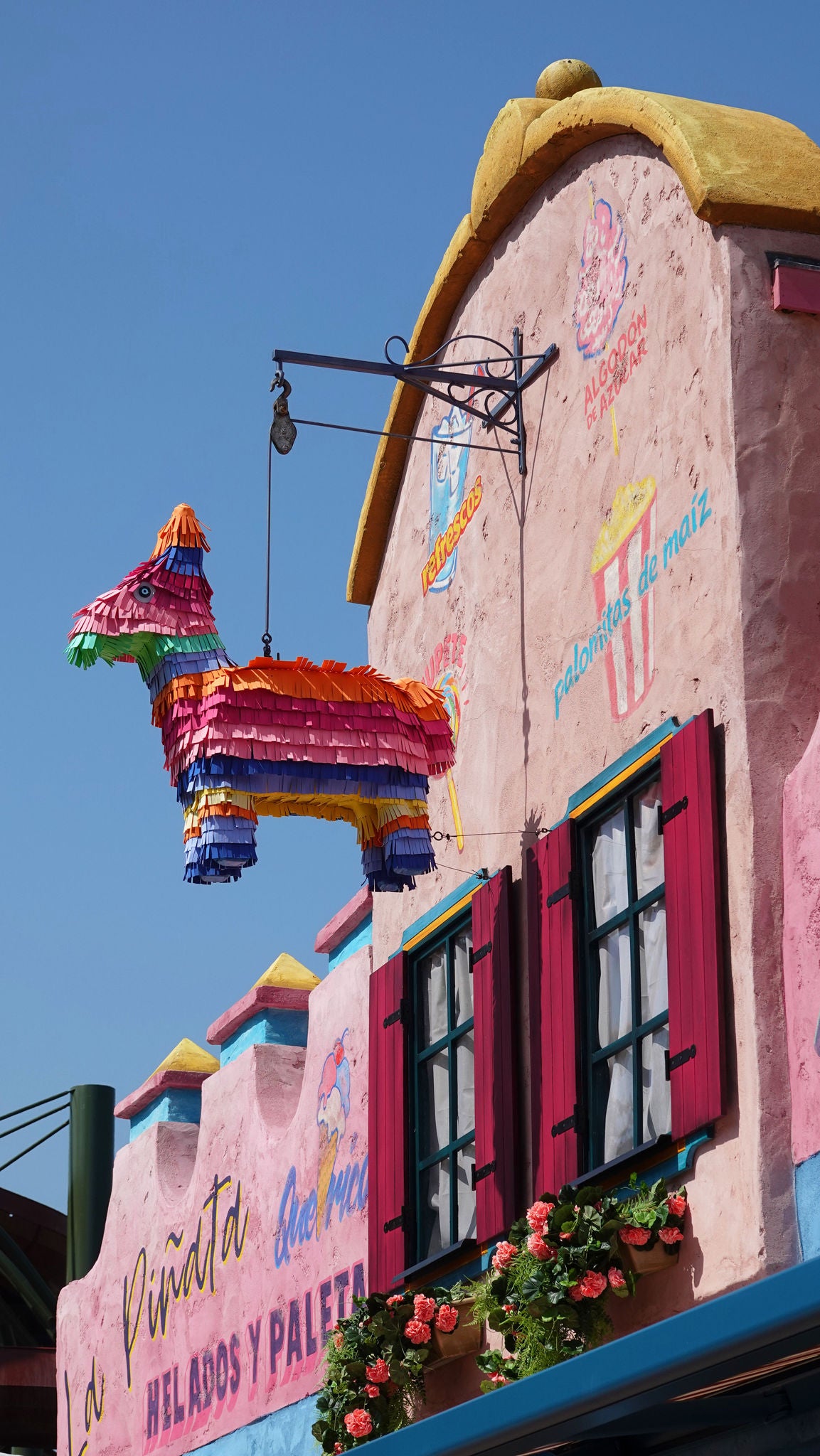Gevel van La Piñata met een piñata, ramen en bloemen.